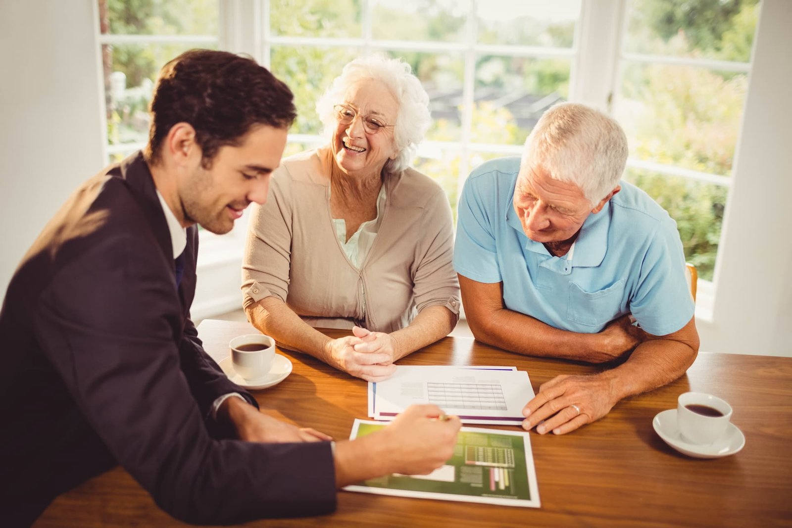 businessman-showing-sheets-senior-couple-home (1)